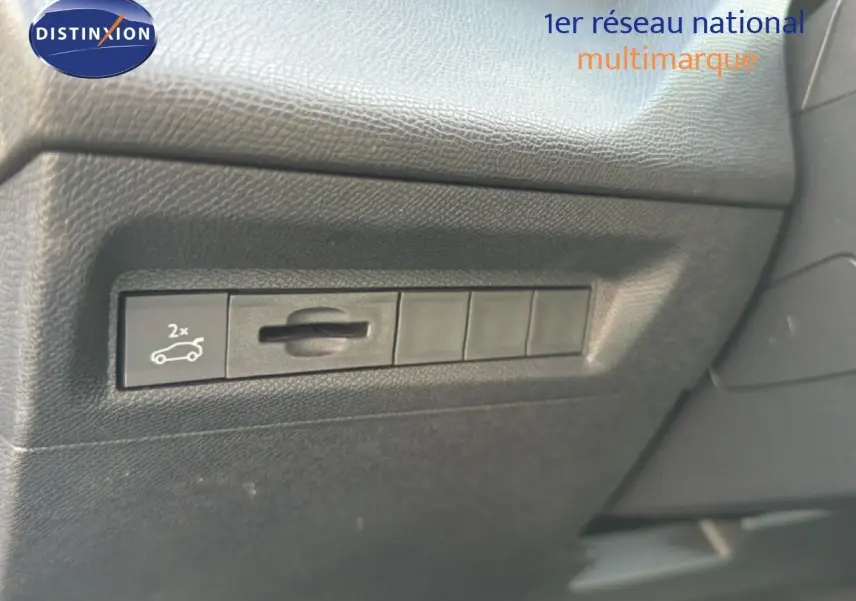 Vue rapprochée sur le tableau de bord noir texturé avec bouton d'ouverture du coffre de la Peugeot 408 gris selenium metal.