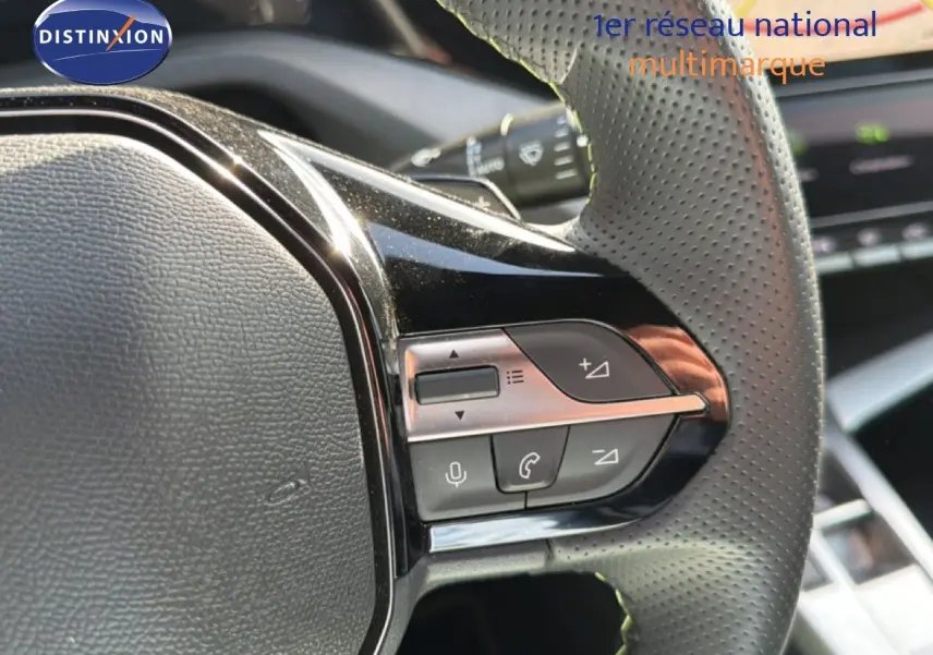 Gros plan sur les commandes multifonctions du volant en cuir perforé d’une Peugeot 408 gris selenium metal 2025.