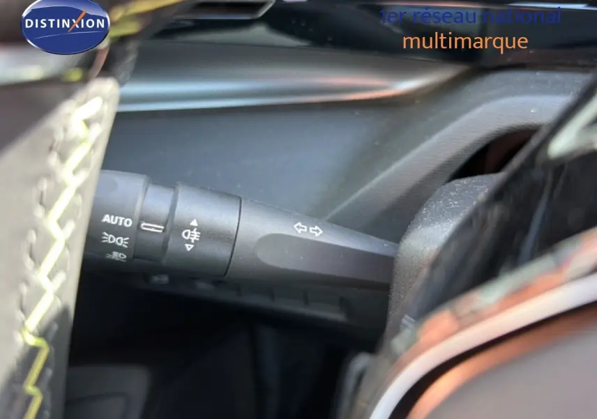 Gros plan sur la commande des clignotants côté gauche dans l’habitacle noir d’une Peugeot 408 gris selenium.