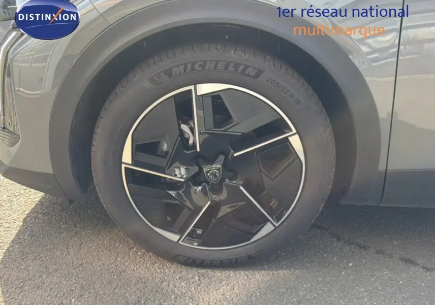 Gros plan sur la roue avant gauche d'une Peugeot 408 gris selenium metal avec jante noire et argentée au design moderne.