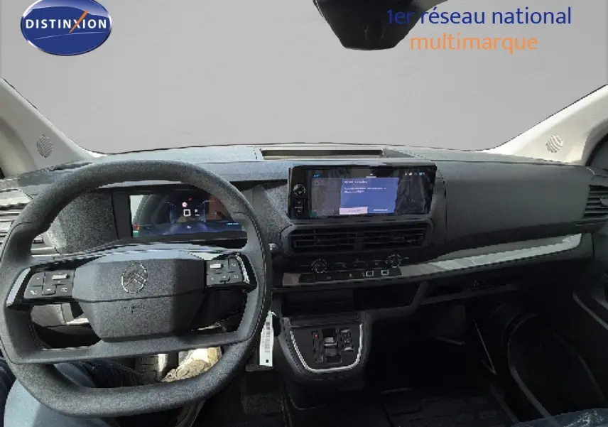 Vue intérieure frontale du tableau de bord du Citroën Jumpy blanc Kaolin avec volant multifonction et écran tactile central.