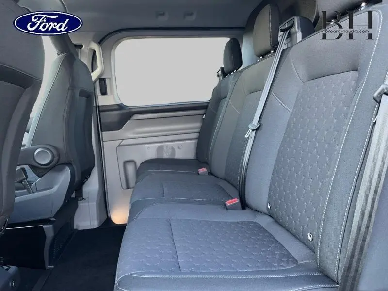 Vue intérieure côté droit du Ford Transit Custom Fourgon 2025, montrant la banquette arrière grise et les ceintures de sécurité.
