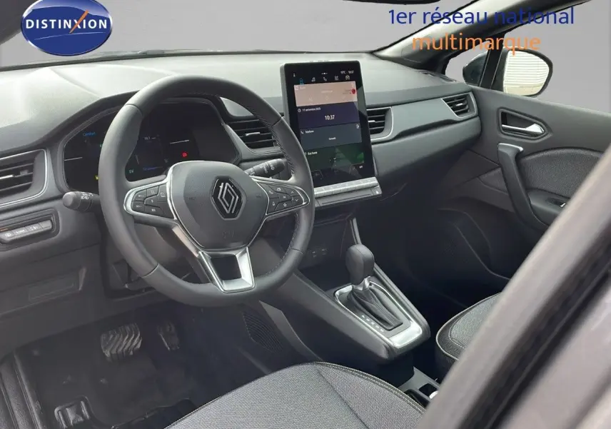 Intérieur du Renault Captur E-Tech hybride 2025, vue côté conducteur sur volant, écran tactile et console centrale.