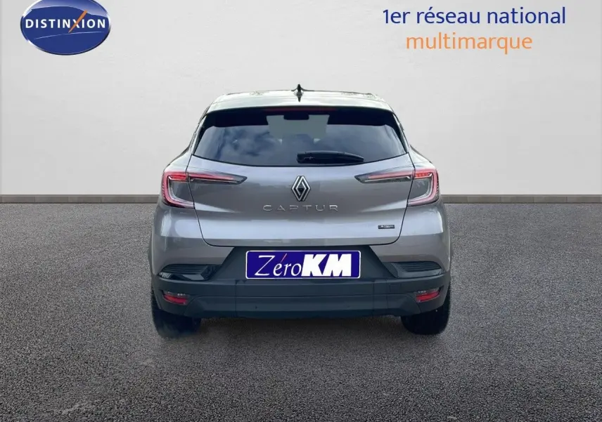 Vue arrière d'un Renault Captur gris cassiopée métal avec toit noir, modèle hybride 2025, sur fond neutre.