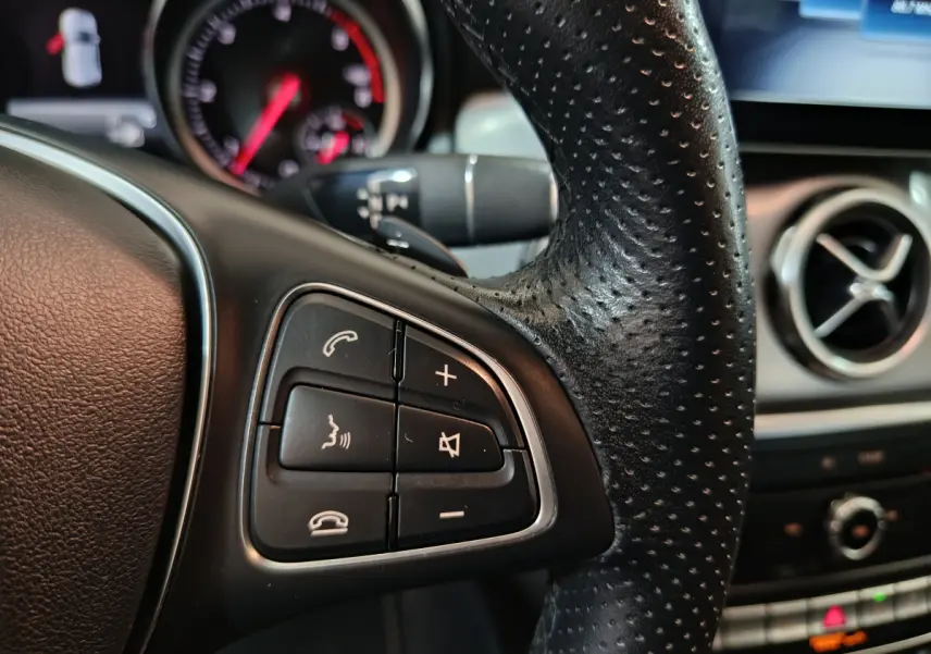 Gros plan sur le volant cuir noir perforé et commandes multifonctions du Mercedes GLA 200 d Business Executive 2018.