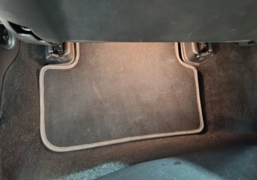 Tapis de sol noir sous le siège avant d’un Mercedes GLA 200 d Business Executive gris clair, vue intérieure basse.