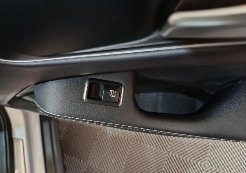 Bouton de commande de vitre sur la portière intérieure noire du Mercedes GLA 200 d Business Executive gris clair.