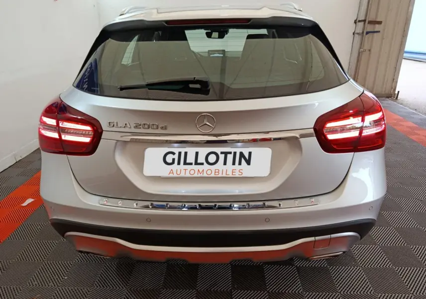 Vue arrière d'un Mercedes GLA 200 d gris clair avec feux LED allumés et logo Mercedes visible sur le hayon.