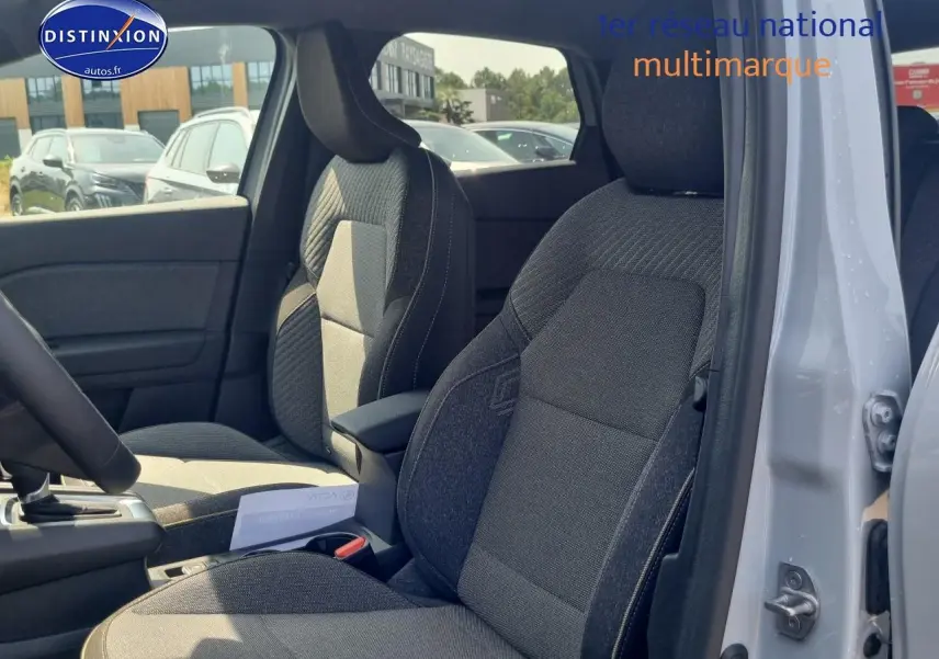 Vue intérieure côté droit du Renault Captur gris rafale 2025, mettant en valeur les sièges tissu et l'accoudoir central.