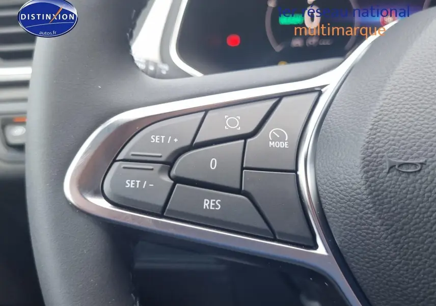 Gros plan sur les commandes multifonctions du volant du Renault Captur gris rafale 2025 hybride.