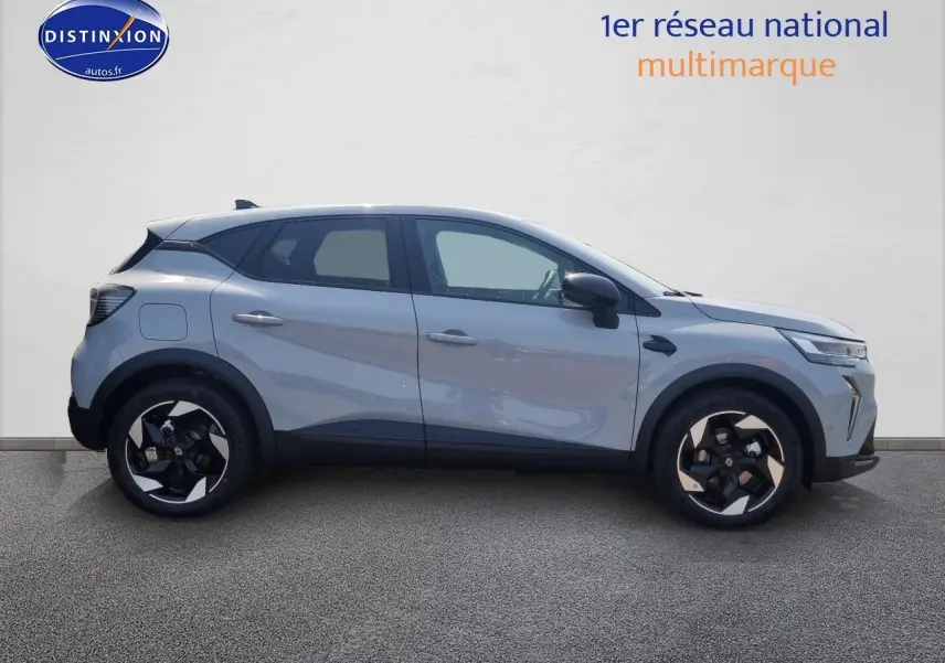Profil droit d'un Renault Captur gris rafale 2025 avec jantes alliage au design moderne et toit noir contrasté.