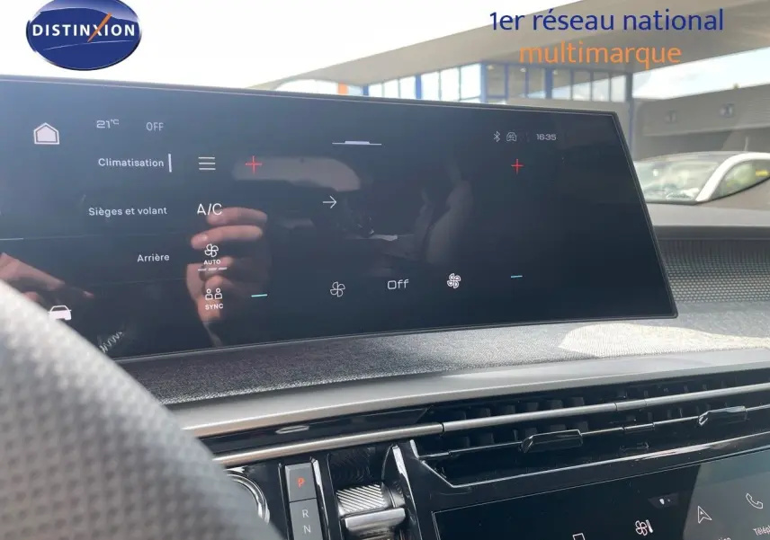 Vue intérieure du tableau de bord du Peugeot 5008 Hybrid 2025 noir perle métal avec écran tactile central et commandes climatisation visibles