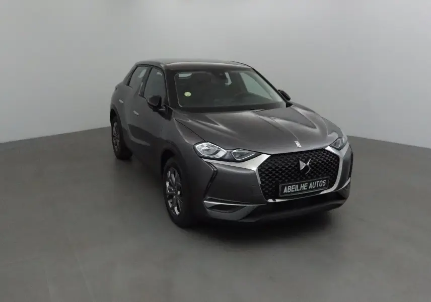 DS3 Crossback gris platinium en 3/4 avant droit, avec calandre hexagonale et logo DS bien visible.