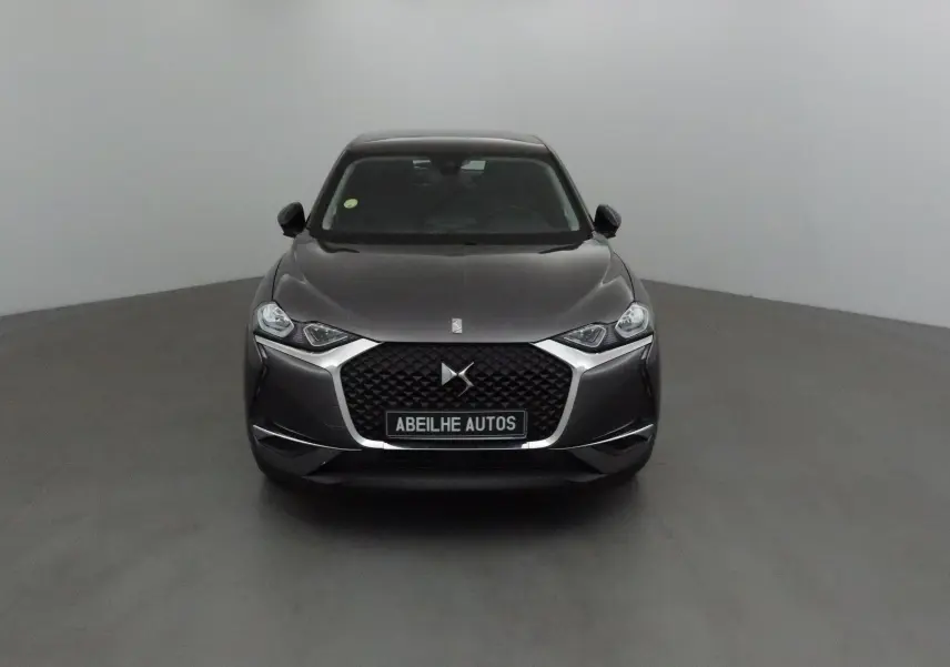 Vue frontale d'un DS3 Crossback gris platinium avec calandre noire et logo DS bien visible.