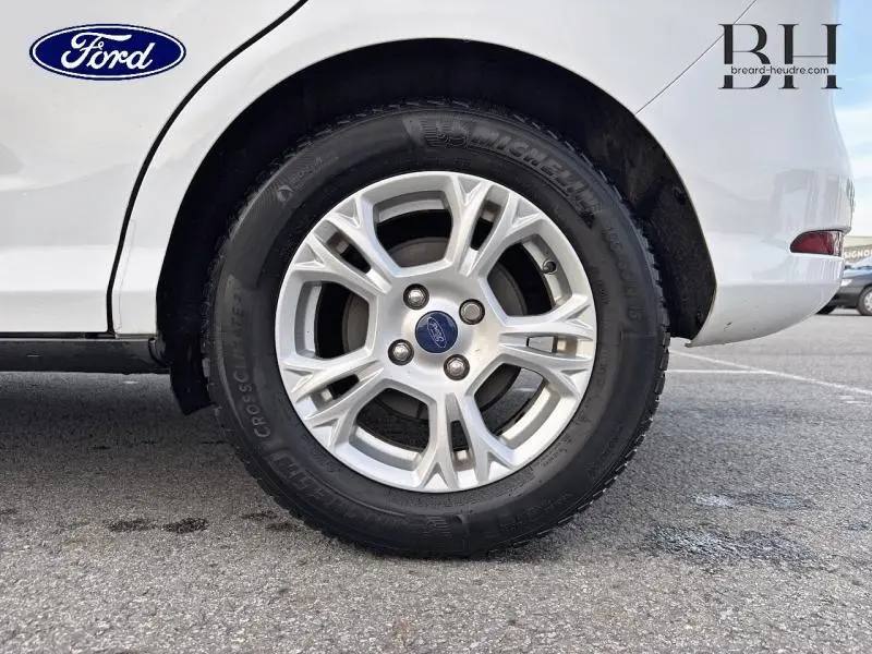 Gros plan sur la roue arrière droite d'une Ford B-MAX blanche Glacier avec jante alliage et logo Ford central.