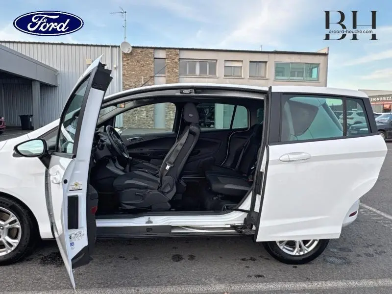 Vue latérale gauche d'une Ford B-MAX blanc glacier 2017 avec portes ouvertes dévoilant l'intérieur et les sièges noirs.