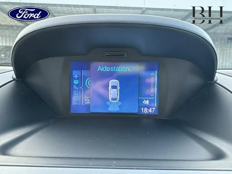 Écran multifonction intérieur du Ford B-MAX blanc montrant l'aide au stationnement en cours à 18h47.