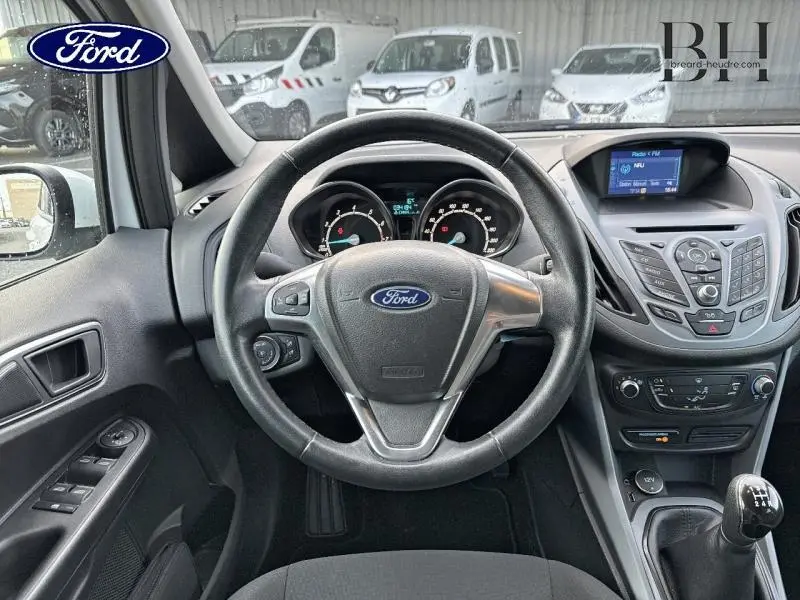 Intérieur noir de Ford B-MAX 2017, vue frontale sur volant cuir, tableau de bord et console centrale avec écran tactile.