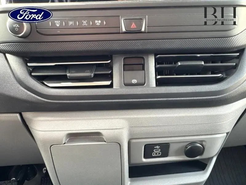 Détail de la console centrale du Ford Transit Custom Fourgon 2025 avec commandes de climatisation et prises USB visibles