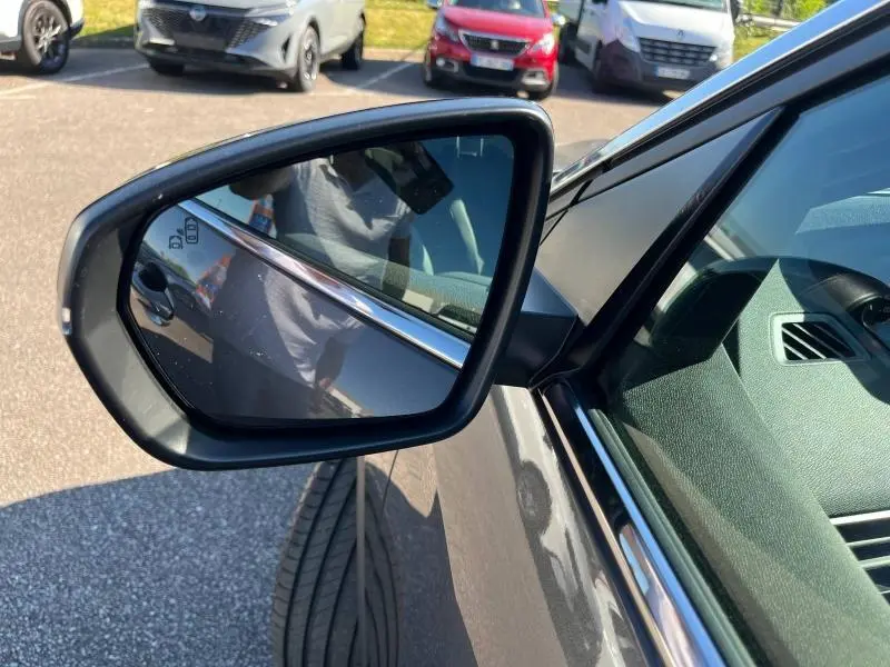 Rétroviseur côté gauche du Peugeot 5008 gris Artense 2024, avec reflet du véhicule et partie intérieure visible.