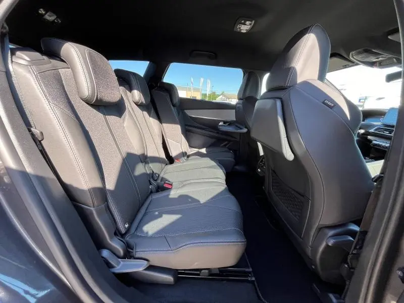 Vue latérale intérieure des sièges arrière gris du Peugeot 5008 2024 avec finitions tissu Belomka et inserts carbone.