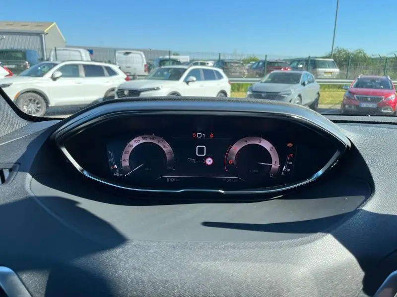 Tableau de bord numérique du Peugeot 5008 2024, affichant vitesse et compte-tours dans un habitacle gris.