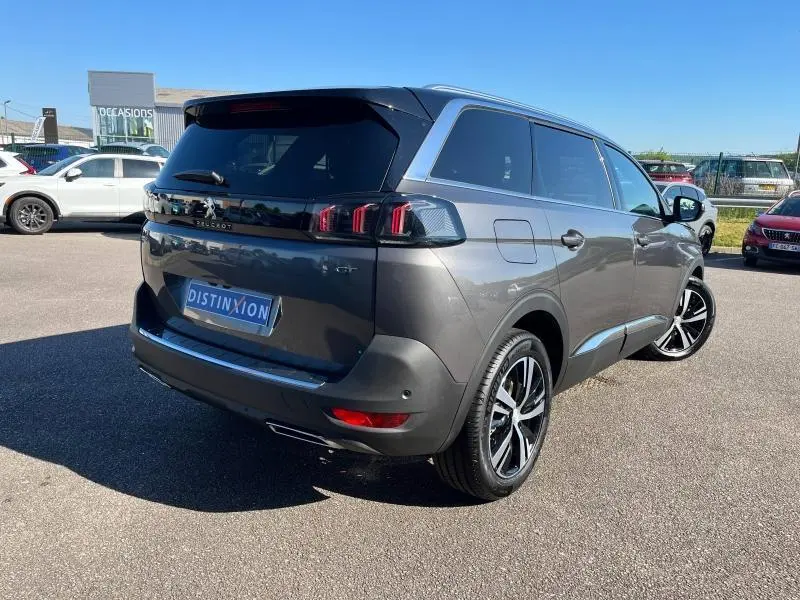 Vue 3/4 arrière droite d'un Peugeot 5008 gris Artense avec jantes alliage et feux arrière LED à effet 3D.