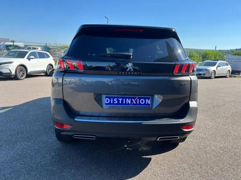 Vue arrière d'un Peugeot 5008 gris Artense 2024 avec feux LED distinctifs et double sortie d'échappement chromée.