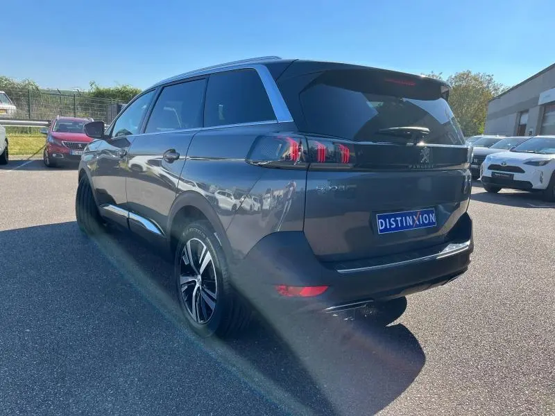 Vue 3/4 arrière droite d'un Peugeot 5008 gris Artense avec feux arrière LED et jantes alliage bi-ton.
