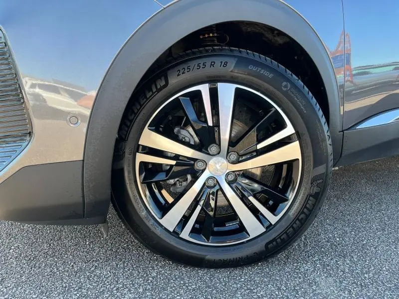 Gros plan sur la roue avant gauche du Peugeot 5008 gris Artense avec jante alliage bicolore et pneu Michelin.