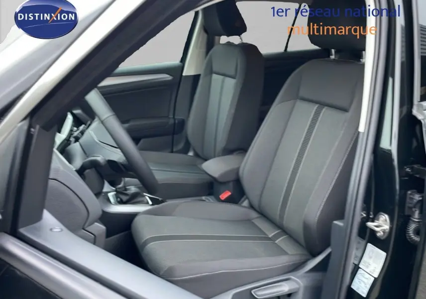 Vue intérieure côté gauche du Volkswagen T-Roc noir Grenadilla, mettant en valeur les sièges tissu avec détails gris et volant multifonction.