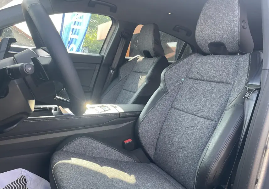 Vue intérieure côté conducteur de la Renault Rafale 2025, sièges sport gris textile avec surpiqûres argentées.