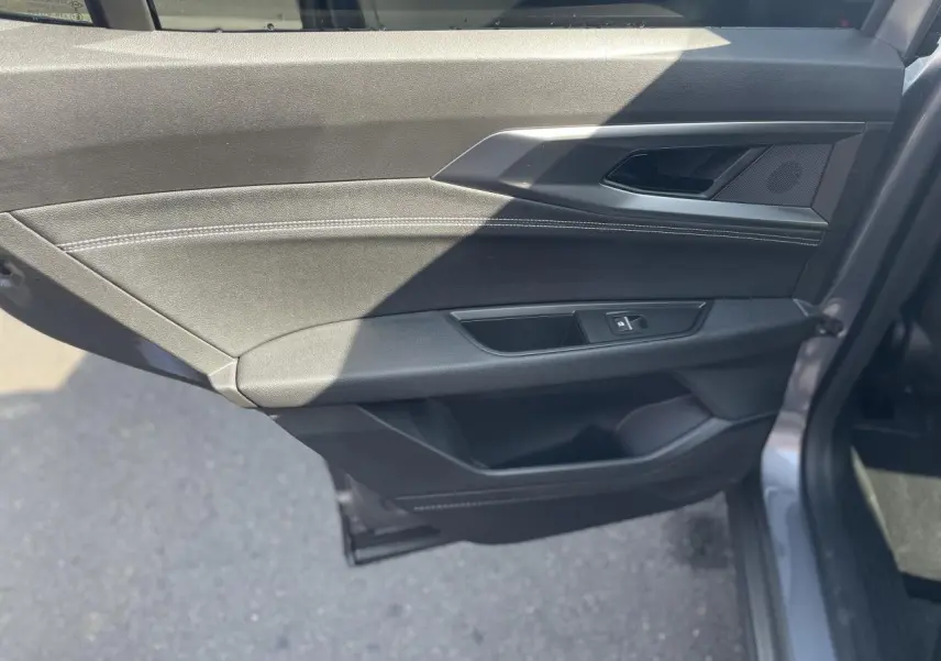 Vue rapprochée de la porte arrière droite gris foncé du Renault Rafale 2025 avec surpiqûres argentées et commande de vitre.