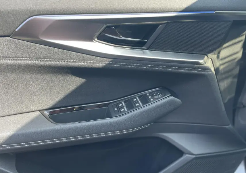 Gros plan sur la porte côté gauche de la Renault Rafale 2025, avec garniture noire et commandes de vitres intégrées.