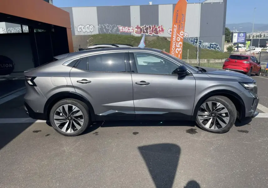 Vue de profil côté gauche d’un Renault Rafale gris avec toit noir, jantes alliage et lignes sculptées modernes.