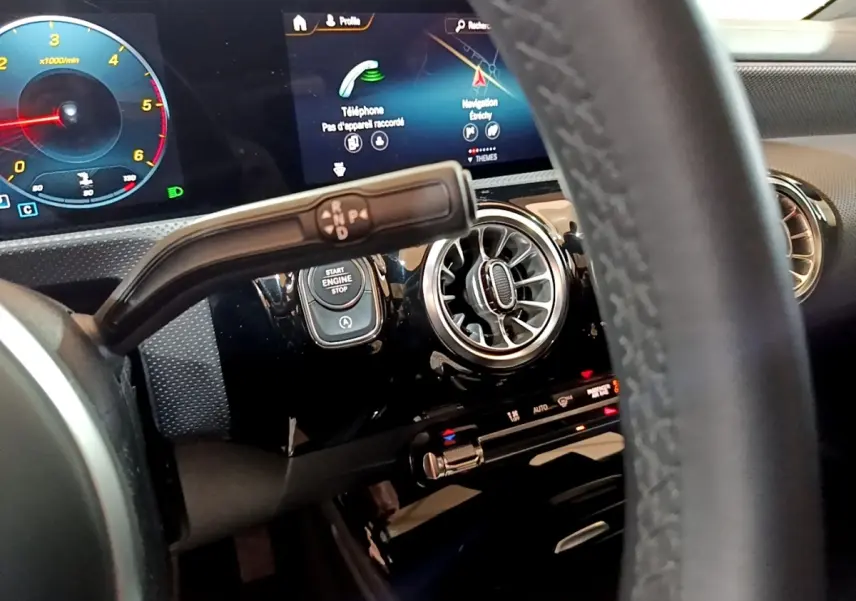 Vue rapprochée du tableau de bord noir de la Mercedes Classe A 200 d, avec écran tactile et volant partiellement visible.