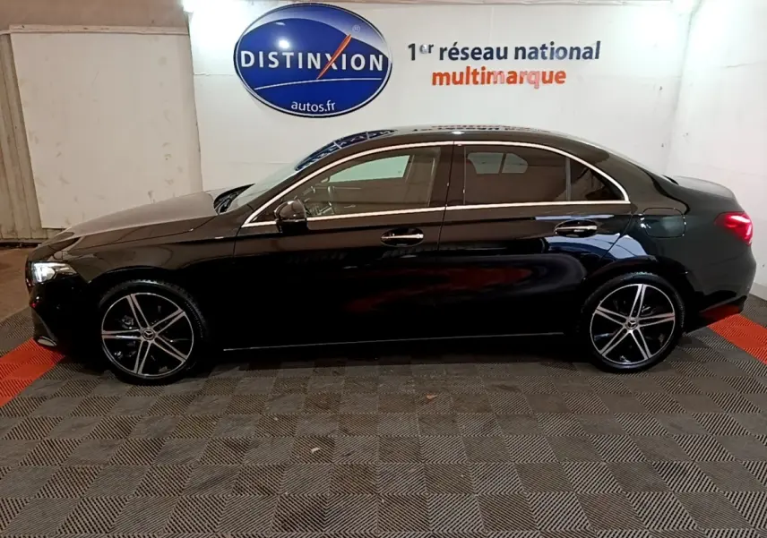 Profil droit d'une Mercedes Classe A Berline noire 2022, avec jantes alliage et feux arrière allumés en intérieur.