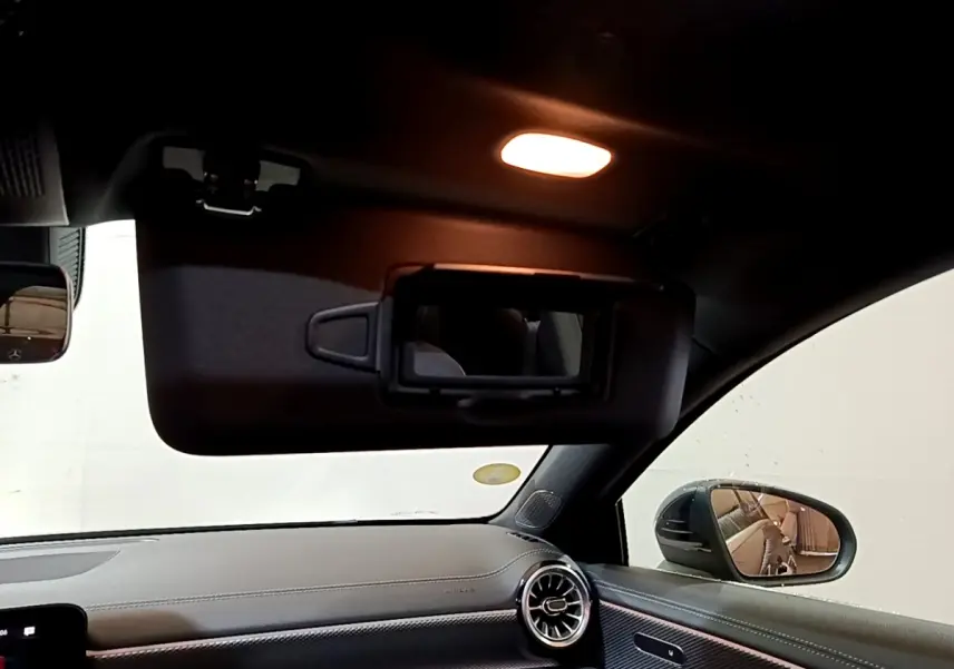 Intérieur de la Mercedes Classe A 200 d Progressive Line 2022, vue côté passager avec pare-soleil ouvert et éclairage intérieur allumé.