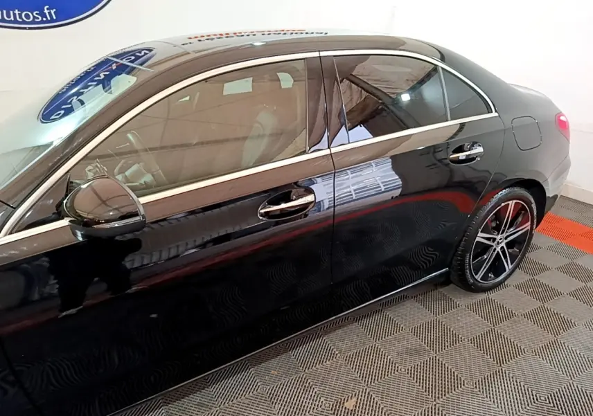 Vue latérale droite d'une Mercedes Classe A berline noire avec jantes alliage et poignées chromées.