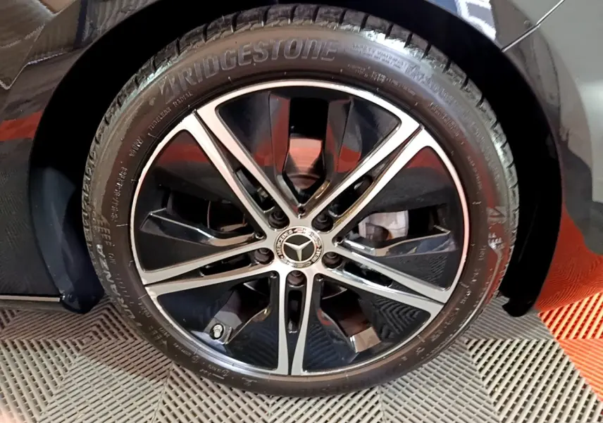 Gros plan sur la roue avant droite noire d'une Mercedes Classe A 200 d Progressive Line 2022 avec jante alliage bicolore.