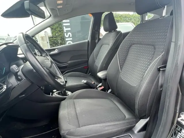 Intérieur de la Ford Fiesta gris 2018, vue côté conducteur montrant sièges en tissu et volant multifonction.