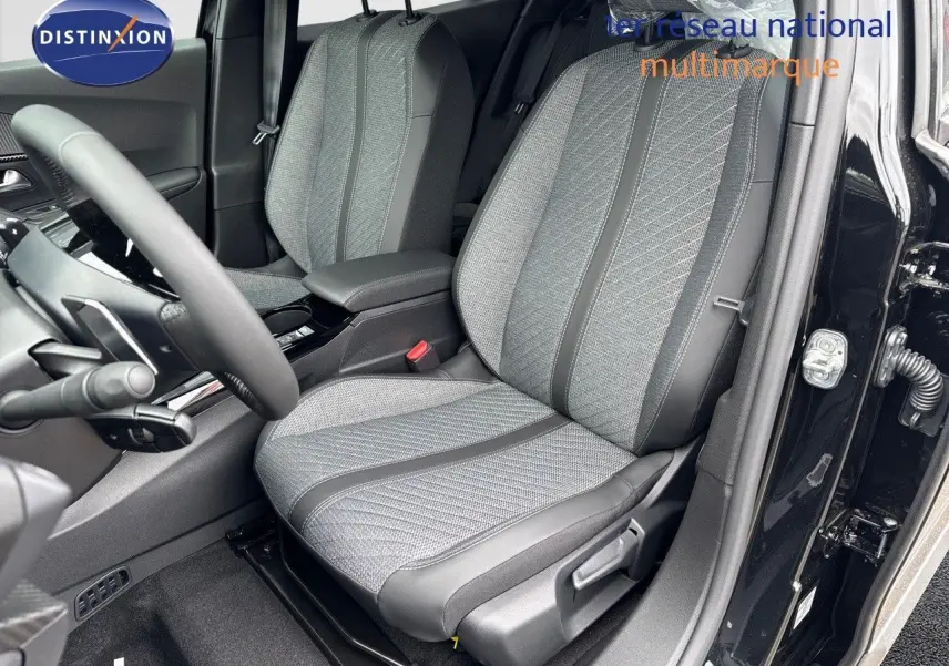 Vue intérieure côté conducteur du Peugeot 2008 noir métal 2025, sièges tissu et cuir noir avec motifs gris.