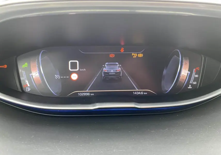 Affichage numérique du tableau de bord du Peugeot 3008 blanc, montrant la vitesse à 0 km/h et l'alerte de distance de sécurité.