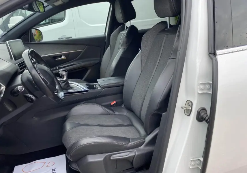 Vue intérieure côté conducteur du Peugeot 3008 blanc nacré 2018, sièges TEP et tissu gris avec volant compact.