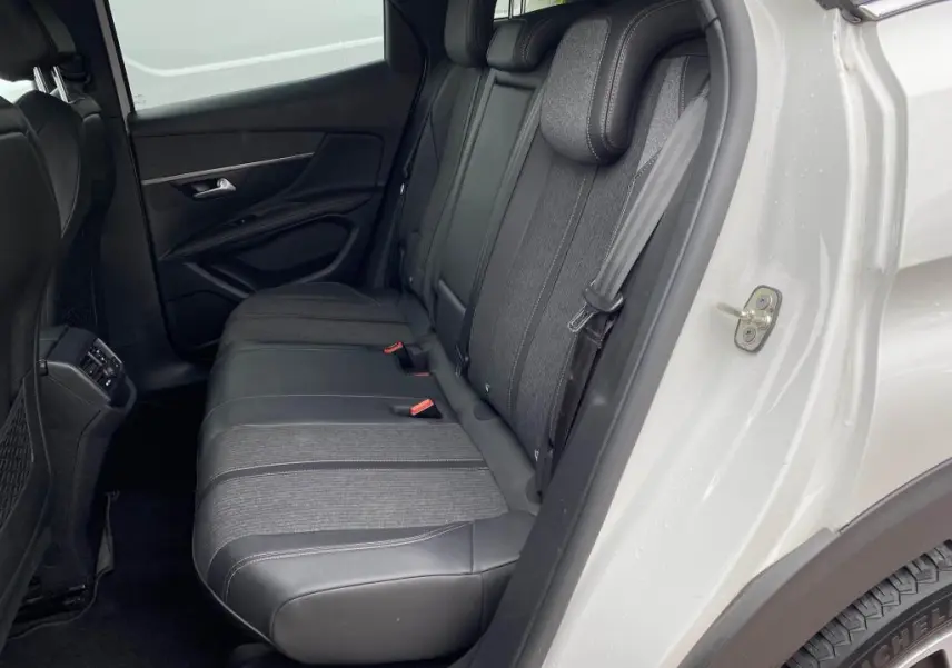 Vue côté gauche des sièges arrière en tissu et cuir noir du Peugeot 3008 blanc nacré 2018 avec porte ouverte.