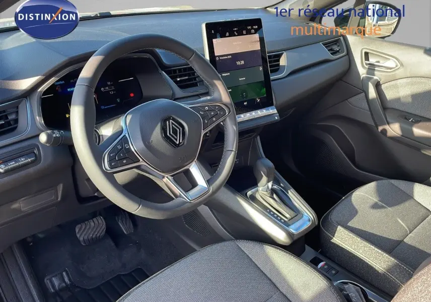 Intérieur du Renault Captur E-Tech Hybrid 2025 vu côté conducteur, tableau de bord moderne avec écran tactile vertical.