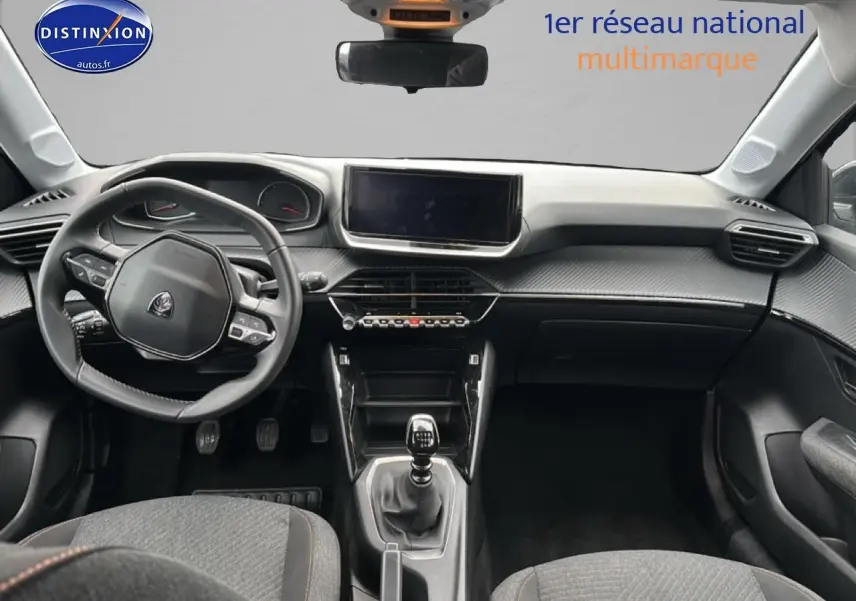 Vue intérieure avant de la Peugeot 208 1.2 100 style 2025, volant compact et tableau de bord moderne avec écran tactile.