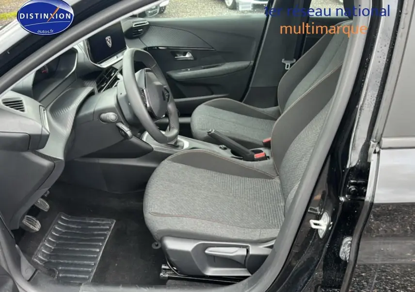 Vue intérieure côté conducteur de la Peugeot 208 noire 1.2 100 style avec sièges gris et tableau de bord moderne.