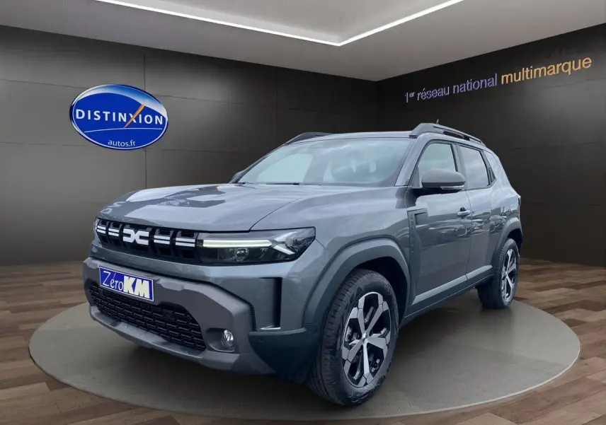 Vue 3/4 avant droite du Dacia Duster Full Hybrid 140 Journey gris schiste avec jantes spécifiques et calandre marquée.