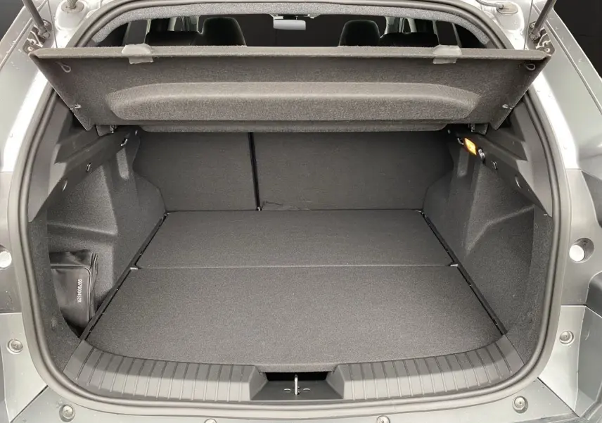 Coffre ouvert du Dacia Duster Full Hybrid 140 Journey 2025 gris schiste, vue arrière montrant l’espace de chargement plat.